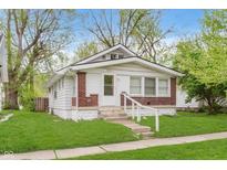 Charming home with white siding, brick accents, and a well-maintained front lawn at 625 N Grant Ave, Indianapolis, IN 46201