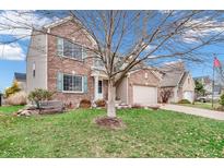 Charming two-story brick home featuring a well-manicured lawn and attached two-car garage at 14446 Chapelwood Ln, Fishers, IN 46037