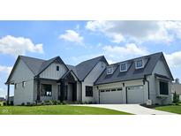 Beautiful new construction home featuring a three car garage, stone exterior and a manicured lawn at 16298 Grand Cypress Dr, Noblesville, IN 46060