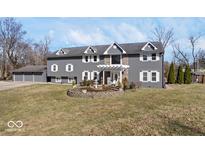 Charming two-story home featuring gray siding, white trim, and a beautifully landscaped front yard at 2227 Hidden Orchard Ct, Indianapolis, IN 46228