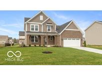 Charming two-story home with a well-manicured lawn, brick and siding exterior and an attached two-car garage at 15468 Streamwood Dr, Fishers, IN 46037