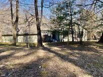 Exterior view of a home with a wood walkway leading to the front door, surrounded by mature trees at 4660 W Cardinal Pt, Trafalgar, IN 46181