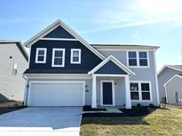 Charming two-story home with a two-car garage, a dark blue accent and a well-maintained lawn on a sunny day at 1019 Cyprian Way, Lebanon, IN 46052
