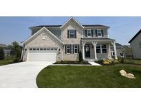 Beautiful two-story home with a well-manicured lawn, attached two car garage, and light colored brick at 12023 Crestwater Ct, Fishers, IN 46037