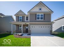 Charming two-story home with neutral siding, well-manicured lawn, and a two car garage at 1567 Hanover St, Danville, IN 46122