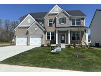 Charming two-story home with a well-manicured lawn, two-car garage, and stone and brick facade at 4958 Reavie Ct, Noblesville, IN 46062