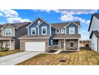 Charming two-story home with blue siding, brick accents, attached two-car garage, and well-maintained lawn at 7062 English Oak Dr, McCordsville, IN 46055