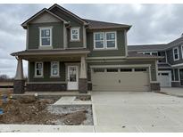 Charming two-story home featuring green siding, a two-car garage, and a concrete driveway at 16043 Meadow Frost Ct, Fishers, IN 46037