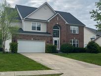Traditional two-story home featuring a brick facade, an attached two-car garage, and a well-maintained lawn at 13271 Lorenzo Blvd, Carmel, IN 46074