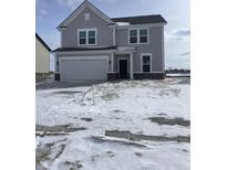 Charming two-story home with a two-car garage, gray siding and a manicured lawn. Snow on the ground at 239 Ambassador Dr, Pittsboro, IN 46167