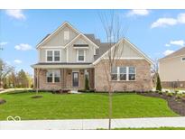 Charming two-story home with brick and siding exterior and beautifully landscaped front yard at 6973 Oakdale Ln, Avon, IN 46123