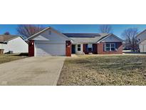 Charming single-story home with red brick accents, solar panels, and an attached two-car garage at 6110 Prairie Stream Way, Columbus, IN 47203