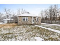 Cozy bungalow with snow-covered lawn and walkway at 11623 Deanna Dr, Indianapolis, IN 46229