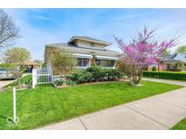 Charming home with well-maintained lawn, white picket fence, and blooming tree at 1641 Winton Ave, Indianapolis, IN 46224