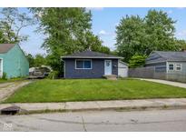 Charming single-story home featuring a well-maintained lawn, blue door, and convenient detached garage at 3125 N Tacoma Ave, Indianapolis, IN 46218