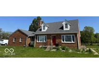 Charming brick home featuring a red door and dormer windows under a gray roof at 3192 E Main St, Plainfield, IN 46168