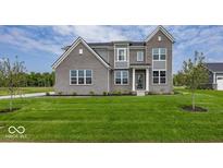Inviting two-story home with a well-manicured lawn and classic gray brick facade at 6596 Dogwood Dr, McCordsville, IN 46055