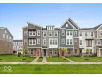 Charming townhomes with colorful doors and well-maintained lawns in a friendly neighborhood setting at 7340 W County Road 600 Rd, McCordsville, IN 46055