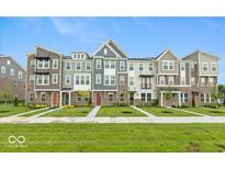 Beautiful townhomes featuring varied colors, brick accents, and professionally landscaped yards with sidewalks and green grass at 7344 W County Road 600, McCordsville, IN 46055