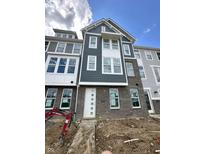 New construction townhome with brick facade, gray siding, and white trim under a cloudy sky at 7344 W County Road 600, McCordsville, IN 46055