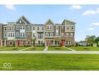 New townhomes feature brick accents, colorful front doors, and manicured landscaping at 7352 W County Road 600, McCordsville, IN 46055