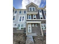 New two-story townhome featuring brick accents and modern architectural details at 7352 W County Road 600 Rd, McCordsville, IN 46055