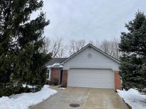 Brick ranch home with attached garage and snow-covered landscaping at 11336 Cherry Blossom W Dr, Fishers, IN 46038