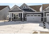 Charming home featuring a two-car garage, stone accents, and a beautifully designed roof in a winter setting at 3509 Wrangler Dr, Bargersville, IN 46106