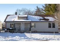 Tan house with snow covered roof and yard, white front door, and chain link fence at 4934 Manker St, Indianapolis, IN 46227