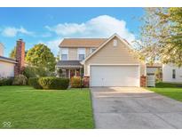 Charming two-story home with an attached two-car garage and a well-maintained lawn at 8908 Torrance Pl, Fishers, IN 46038