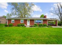 Charming red brick ranch-style home with a well-manicured lawn and attached carport at 56 Hadley Woodland St, Mooresville, IN 46158