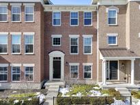 Brick front elevation of a three-story townhome with black door at 9426 Park Meridian Dr, Indianapolis, IN 46260