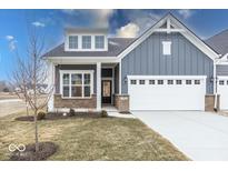 Charming blue two-story home featuring a brick foundation, white trim, and an attached two car garage at 3922 Holly Brook Dr, Westfield, IN 46062