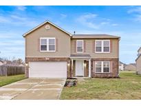 Two-story house with tan siding, brick accents, and a two-car garage at 8414 Ingalls Way, Camby, IN 46113