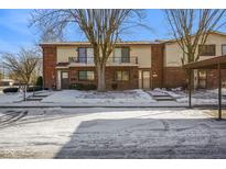 Brick front exterior of twin home with balcony and snowy landscaping at 23 Trails End St, Greenwood, IN 46142