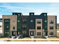 Stylish townhomes boasting brick and modern paneling under a vibrant blue sky with a fresh lawn at 9895 Baneberry Ln, Carmel, IN 46290