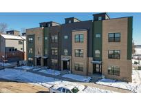 Modern townhomes with brick and metal siding, located in a snow covered neighborhood at 9895 Baneberry Ln, Carmel, IN 46290