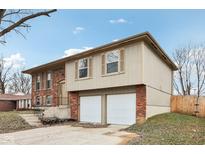 Brick and tan two-story house with a two-car garage and landscaping at 6416 Watercrest Way, Indianapolis, IN 46278