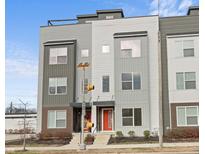 Modern townhouse featuring eye-catching red door and stylish gray horizontal siding, complete with a rooftop deck at 1718 E 10Th St, Indianapolis, IN 46201