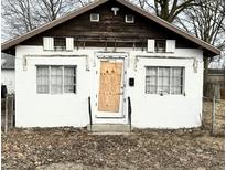 Small home exterior with white painted brick, covered front door, and brown trim at 1214 N Penn St, Muncie, IN 47303