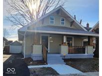 Light green craftsman home with a covered porch and detached garage at 5009 E Michigan E St, Indianapolis, IN 46201