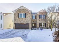 Brick two-story house with a brown garage door and snow-covered yard at 2959 Hearthside Dr, Greenwood, IN 46143