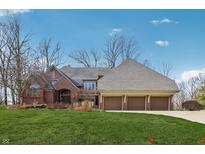 Charming brick home with a three-car garage and well-manicured front lawn at 8110 Bounty Ct, Indianapolis, IN 46236