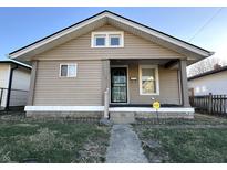 Tan colored house with front porch and small yard at 1719 Nelson Ave, Indianapolis, IN 46203