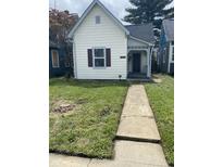 Charming home with white siding, neat front yard and a concrete walkway leading to the front door at 2521 Prospect St, Indianapolis, IN 46203
