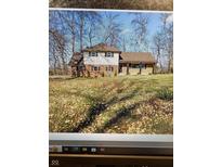 Two story home has brick and siding exterior with covered porch and front yard with fall leaves at 454 Tulip Dr, Mooresville, IN 46158