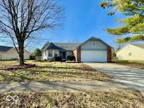 Brick ranch home with attached garage and landscaped yard at 7704 Winding Creek Dr, Indianapolis, IN 46236