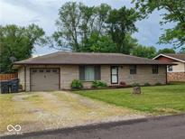 Ranch style home with attached garage and landscaped lawn at 403 Collier St, Columbus, IN 47201