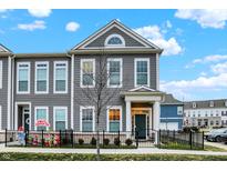 Gray two-story townhome with a front yard and black fence at 597 Steinbeck Pl, Carmel, IN 46032