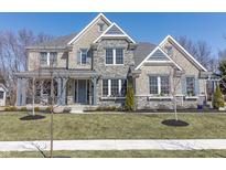 Charming two-story home featuring a stone facade, inviting front porch, and beautifully landscaped front yard at 78 Chatham Brook Dr, Westfield, IN 46074
